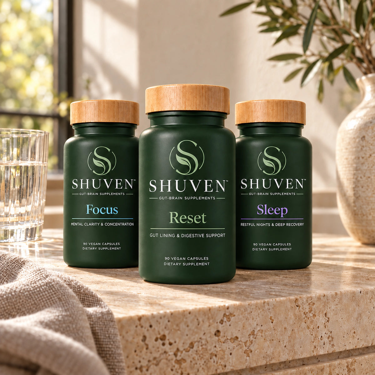 Shuven Starter Bundle with Focus, Reset, and Sleep bottles on a sunlit stone counter; Reset label reads Gut Lining & Digestive Support.